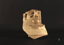 Frammento di urna fittile configurata a volto umano con gli arti superiori schematizzati. Artigianato filisteo.X sec. a.C. Neapolis.