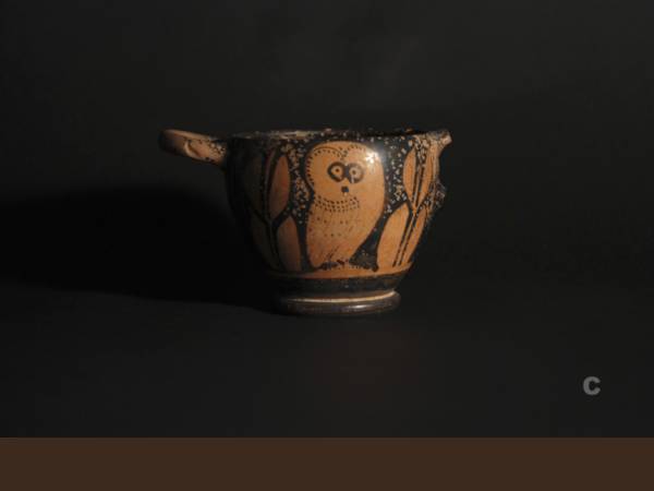 Glaux (vaso per bere vino) attico a figure rosse con rappresentazione di Atena- civetta fra due rami d’ ulivo. 430 a.C. circa. Tharros. Necropoli meridionale.