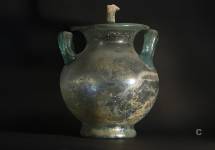 Urna cineraria con anse a omega e coperchio in vetro soffiato verde. I secolo d.C.